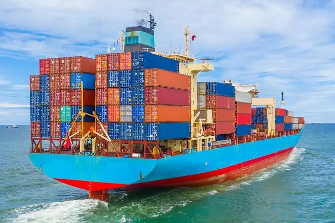 Cargo ship loaded with colorful shipping containers sailing at sea – How Much Does a Cargo Ship Cost concept image