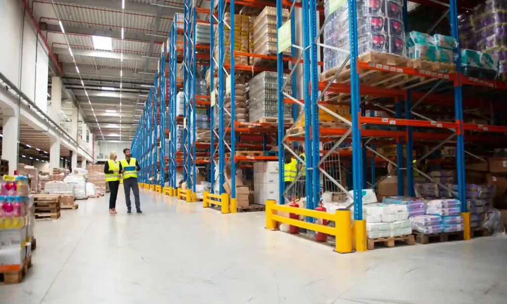 Shared warehouse space with organized storage racks, stacked cartons, and a forklift used by multiple businesses for inventory storage and distribution.