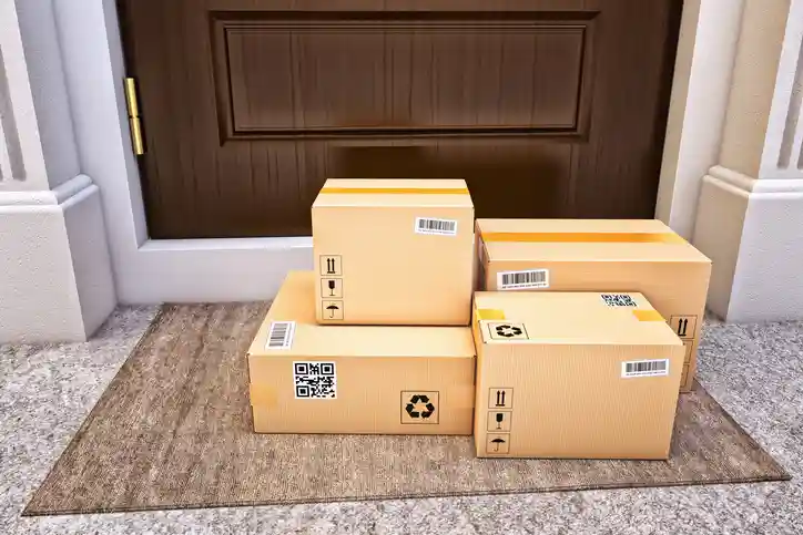 Packages placed on a front doorstep, illustrating the difference between in-home delivery and doorstep delivery.