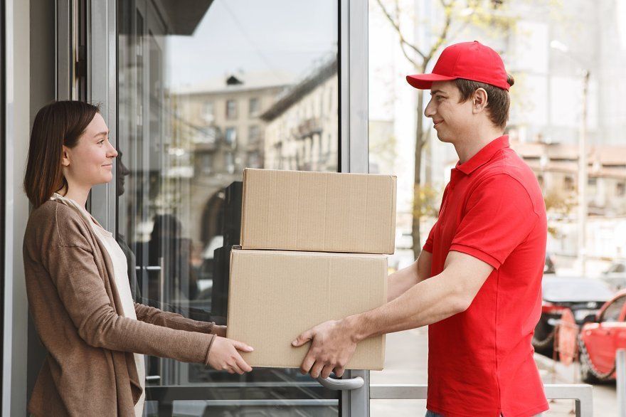 Courier delivery driver handing over packages to a customer at a doorstep in Evans GA for fast and reliable courier delivery service.